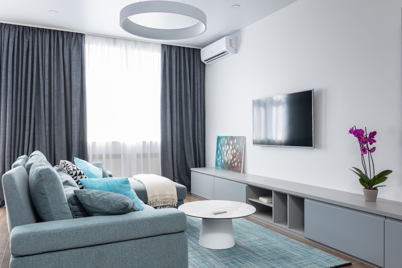 Modern Dubai living room with motorized curtains and smart home app control